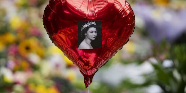 Un globo con una imagen de la reina Isabel II flota sobre las flores en el memorial de Green Park, cerca del Palacio de Buckingham, en Londres, el 10 de septiembre de 2022.