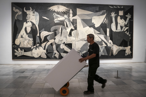 Un trabajador pasa frente a la Guernica, en la instalación por los 50 años de la muerte
del artista en el Museo Reina Sofía, de Madrid, el 12 de septiembre pasado.