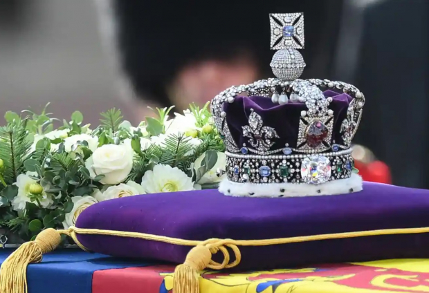 Sobre el Estandarte Real yace la Corona del Estado sobre un cojín de terciopelo morado.