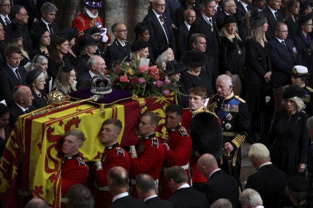 El féretro de la reina Isabel II es cargado mientras el rey Carlos III y la reina consorte Camila lo siguen tras su funeral en la Abadía de Westminster en el centro de Londres