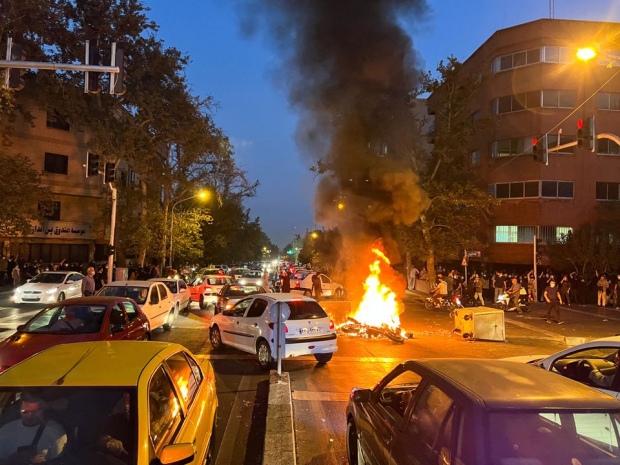 Una motocicleta de la policía arde durante una protesta por la muerte de Mahsa Amini.