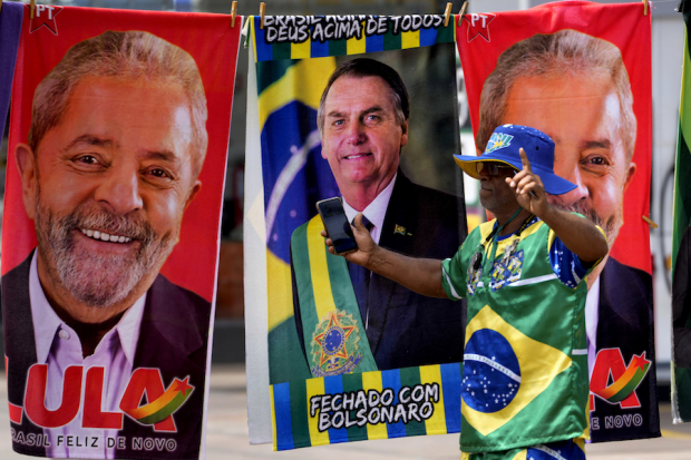 Un hombre posa frente a publicidad de Lula y Jair Bolsonaro, el pasado 27 de septiembre.