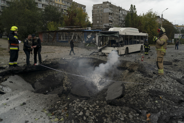 Un cráter en el suelo por el impacto de un misil ruso en Kiev y un camión semicalcinado muestran el nivel de la ofensiva enemiga, ayer.