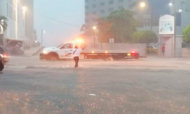 El policía vial dando indicaciones bajo la lluvia