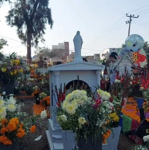 En San Andrés Mixquic, en Tláhuac, cientos de personas acuden a decorar con flores de cempasúchil, calaveras de papel y regalos para sus seres queridos
