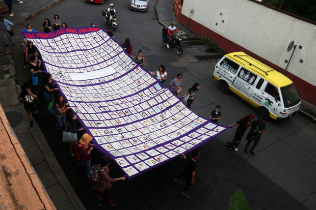 Mujeres hacen una procesión en las calles de Cuernavaca, con una manta que tiene bordados los rostros de 48 víctimas de feminicidio, el mes pasado.