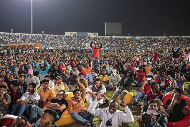 Trabajadores migrantes disfrutan el  partido inaugural del Mundial, ayer, en Doha.