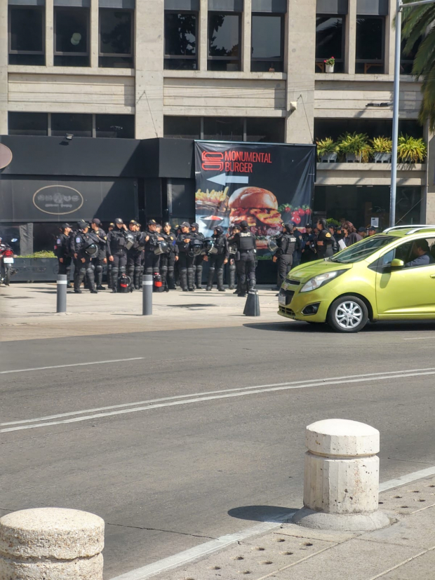 Policías se concentran a las afueras de un comercio, en las inmediaciones del Monumento a la Revolución.