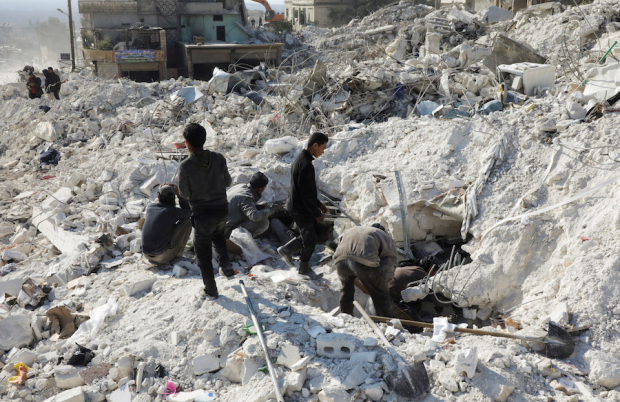 Habitantes buscan sobrevivientes bajo los escombros de uno de  los edificios dañados en la ciudad rebelde de Harem, Siria, ayer.
