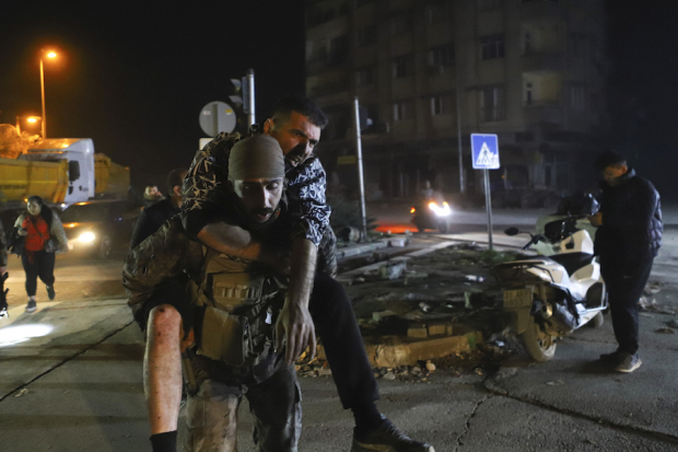 Un soldado auxilia a un hombre lesionado tras el nuevo terremoto.