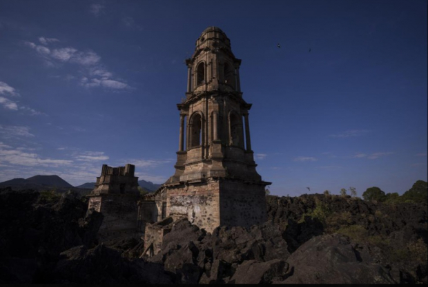 La torre de una iglesia sobresale por encima de la lava del volcán Paricutín que enterró la iglesia hace décadas, en San Juan Parangaricutiro.
