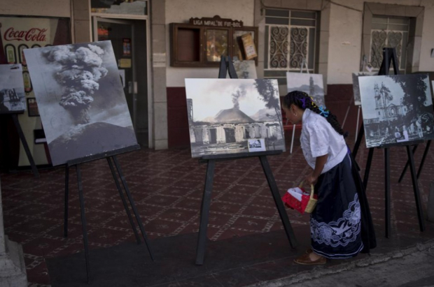 Una chica mira una exhibición sobre fotos históricas del volcán Paricutín en conmemoración de la erupción inicial que duró nueve años, en San Juan Nuevo Parangaricutiro.