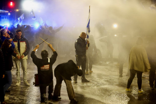 Policías lanzan chorros de agua para disolver las protestas.