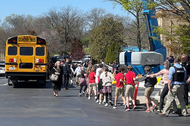 Agentes trasladan a menores durante la evacuación en el Covenant School.