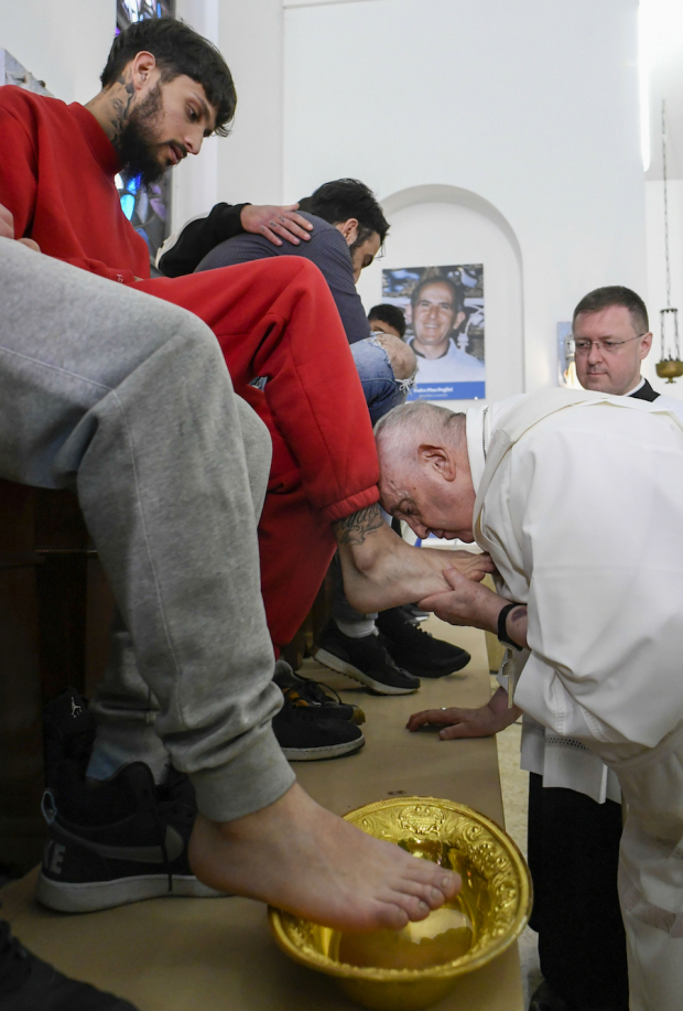 El papa Francisco besa el pie de uno de los 12 internos durante un ritual en Casal del Marmo, ayer.
