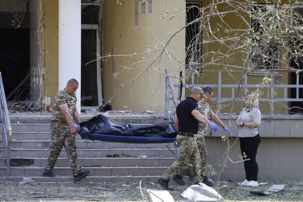 Rescatistas recuperan el cuerpo de una de las tres víctimas halladas tras un bombardeo en Kiev, ayer.