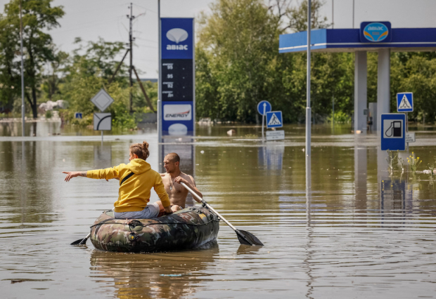 Residentes locales navegan durante una evacuación de un área inundada, en medio del ataque por parte de tropas rusas, ayer en Jerson, Ucrania.