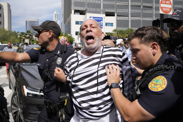 Un hombre vestido de prisionero es detenido tras frenar la caravana del republicano.