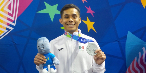 Juan Barco presume la medalla de plata que ganó en levantamiento de pesas, en envión 55 kilos, en los Juegos Centroamericanos y del Caribe San Salvador 2023