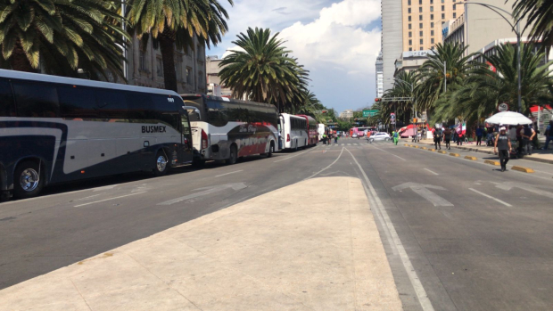 Camiones turísticos estacionados sobre Avenida Juárez.