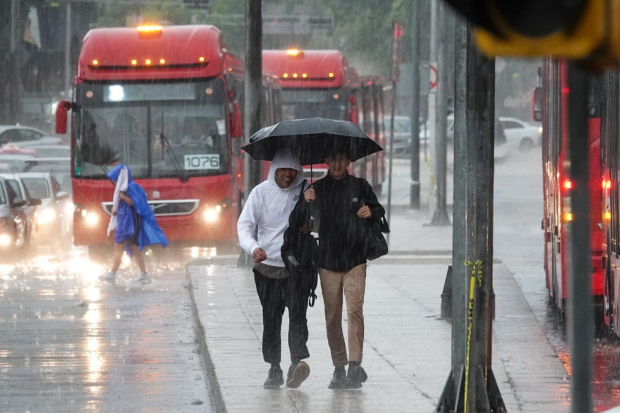 En esta imagen de archivo, capitalinos se cubren de las fuertes lluvias con granizo en avenida Reforma, alcaldía Cuauhtémoc