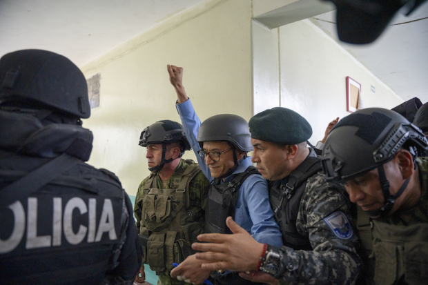 Christian Zurita, sustituto de Fernando Villavicencio, es escoltado por policías y militares en Quito, ayer.