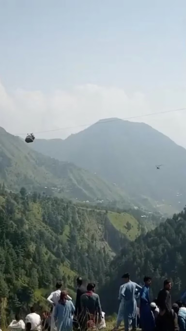Una vista muestra un helicóptero que realiza una operación de rescate junto al teleférico con estudiantes varados en el aire en Battagram, Pakistán, el 22 de agosto de 2023, en esta captura de pantalla obtenida de un video de las redes sociales.