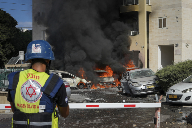 Cuerpos de emergencia observan el incendio provocado por un misil cerca de Gaza, ayer.