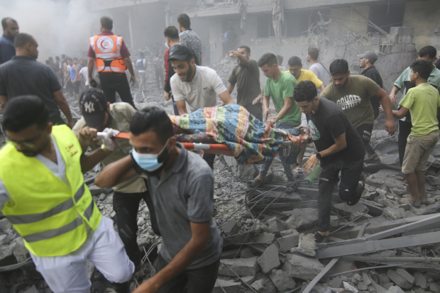 Pobladores palestinos cargan a una persona herida tras un ataque israelí contra Hamas, ayer.