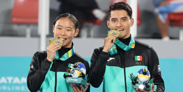 Cecilia Lee y William Arroyo celebran en el podio con la medalla de oro que ganaron en taekwondo poomsae (freestyle mixto) de los Juegos Panamericanos Santiago 2023