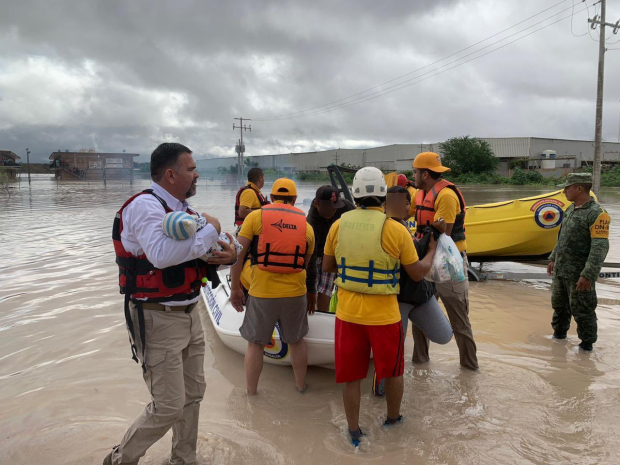 Pobladores de Villa Juárez son rescatados en lanchas tras la contingencia, ayer.