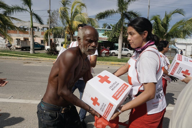 Voluntarios de la Cruz Roja Mexicana entregaron ayuda humanitaria a cientos de familias en inmediaciones de la Glorieta del Puerto Marqués, en Acapulco, ayer.
