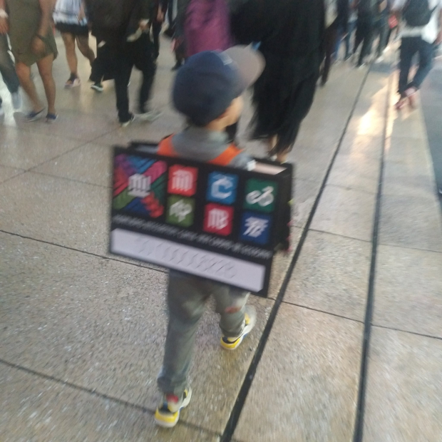 Niño camina por calles del Centro Histórico disfrazado de tarjeta del Metro CDMX.
