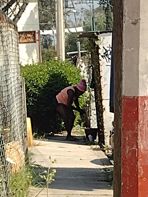 Una mujer lava su ropa en una cubeta en plena calle, cerca de la unidad habitacional Villas de los Trabajadores, en Tláhuac.