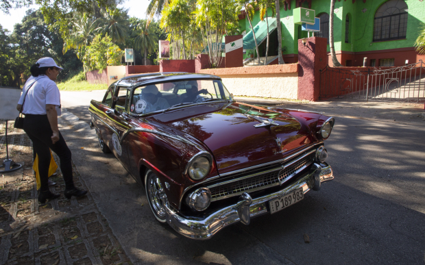 Una oficial de carrera controla un automóvil durante el Rally de Autos Antiguos de La Habana, en La Habana, Cuba, el domingo 3 de diciembre de 2023. El rally celebra el 125to aniversario de la llegada del primer automóvil a la isla