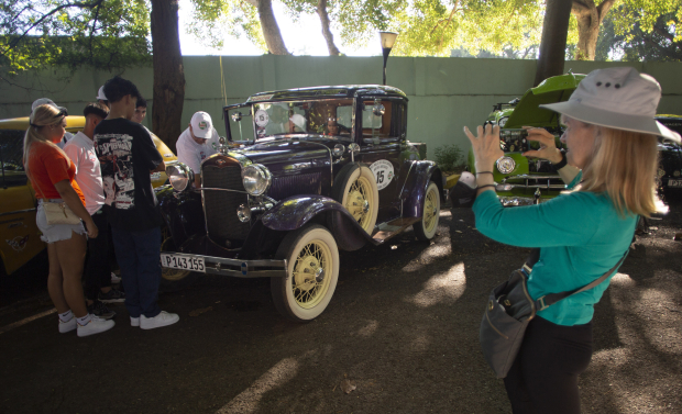 Una turista toma una fotografía de un Ford de los años de 1930, antes del inicio del Rally de Autos Antiguos de La Habana, en La Habana, Cuba, el domingo 3 de diciembre de 2023