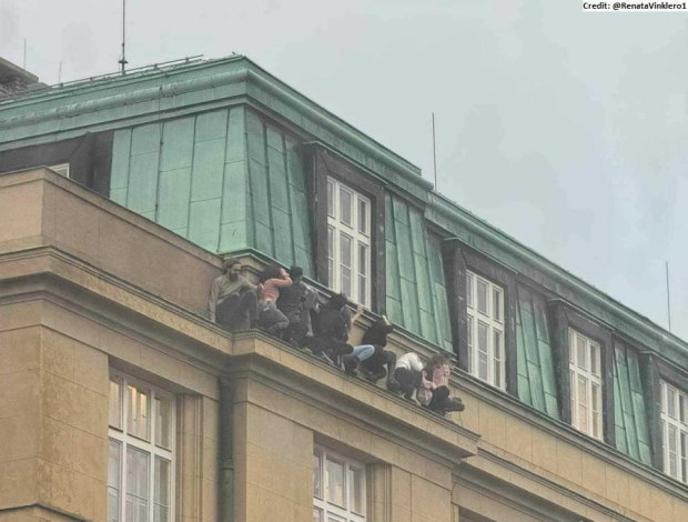 Jóvenes se esconden en la cornisa del edificio para evadir al agresor.