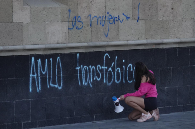 "AMLO transfóbico", escribe una mujer en las paredes de Palacio Nacional.