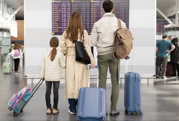 Una familia busca su vuelo en un aeropuerto, en una imagen de stock.