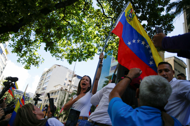 La candidata presidencial de la oposición en Venezuela, María Corina Machado, levanta la bandera nacional durante un evento proselitista en las calles de Caracas, el pasado 23 
de enero.