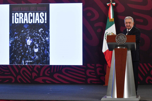 El presidente López Obrador presenta la portada de su próximo libro.