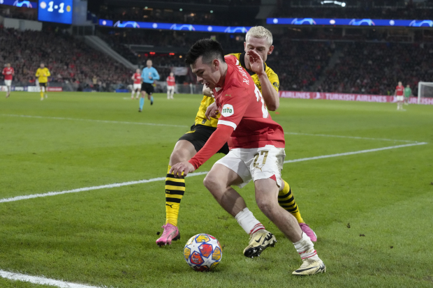 Hirving Lozano pelea un balón con Julian Ryerson en la ida de octavos de final de Champions League entre PSV Eindhoven y Borussia Dortmund.