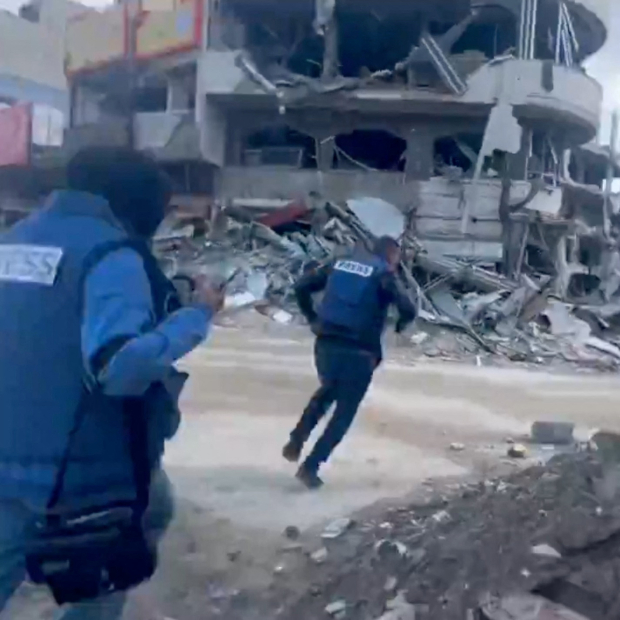 Dos periodistas corren en busca de refugio tras escuchar ofensivas aéreas cerca de su ubicación, en Gaza.