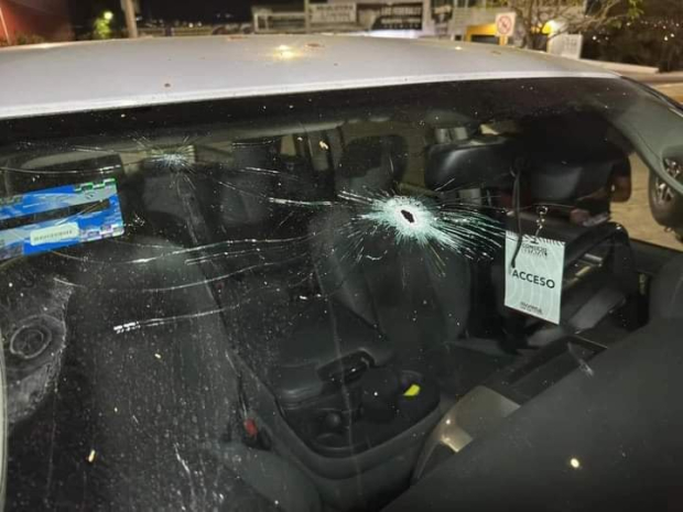 Los impactos de bala atravesaron el cristal frontal del auto.