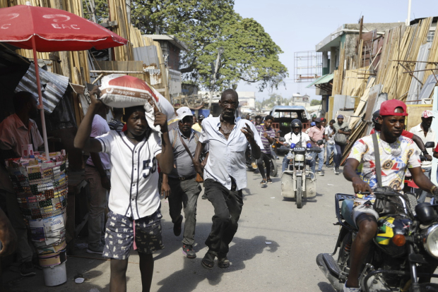 Transeúntes corren para ponerse a salvo tras escuchar disparos, en Puerto Príncipe, Haití.