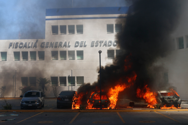 Encapuchados atacan las instalaciones de la FGE de Guerrero lanzando petardos y bombas molotov, y quemaron vehículos que estaban en el lugar, ayer.