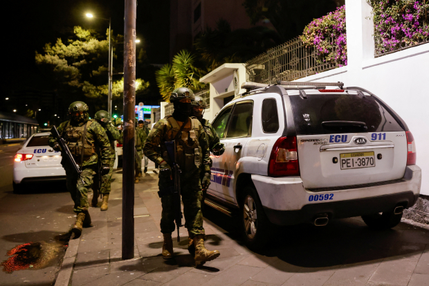Patrullas de la policía resguardan la embajada de México en la ciudad de Quito, mientras oficiales militares caminan afuera de la representación de donde sacaron por la fuerza
al exvicepresidente de Ecuador, Jorge Glas Espinel, el pasado 5 de abril.