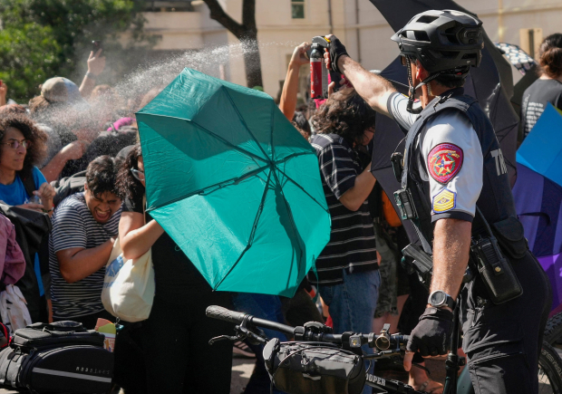 Un policía lanza gas pimienta a disidentes en un plantel de Austin, ayer.
