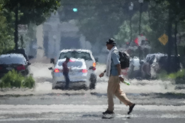 Una persona cruza Caroline Street bajo el intenso calor de la tarde.