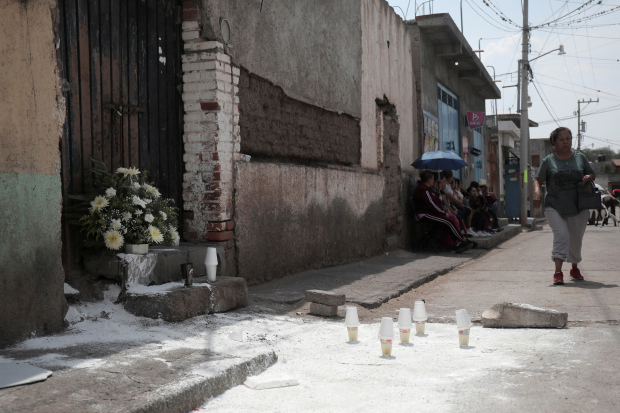 Una mujer pasa este domingo 2 de junio al lado del lugar donde la noche del sábado fue asesinado Israel Delgado Vega candidato de Morena-PT-PVEM a síndico de Cuitzeo, Michoacán.